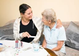 badante che aiuta anziana con medicine